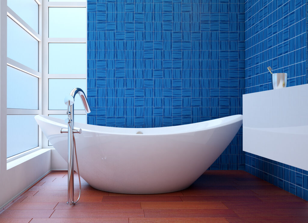 Banheiro com piso de madeira e revestimento azul na parede.