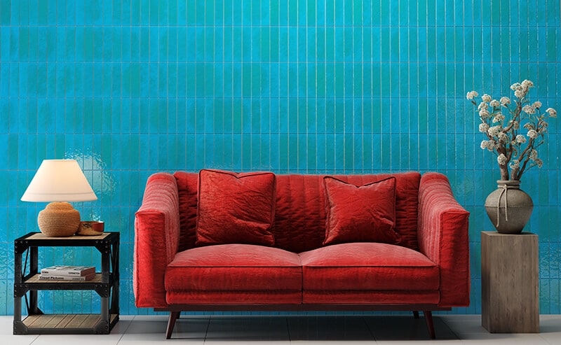 Revestimento azul em sala de estar com sofá vermelho.